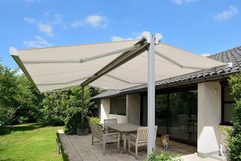 Markise TWINSTOR: freistehende Markise in hellem Farbton auf Terrasse mit Tisch und Stühlen