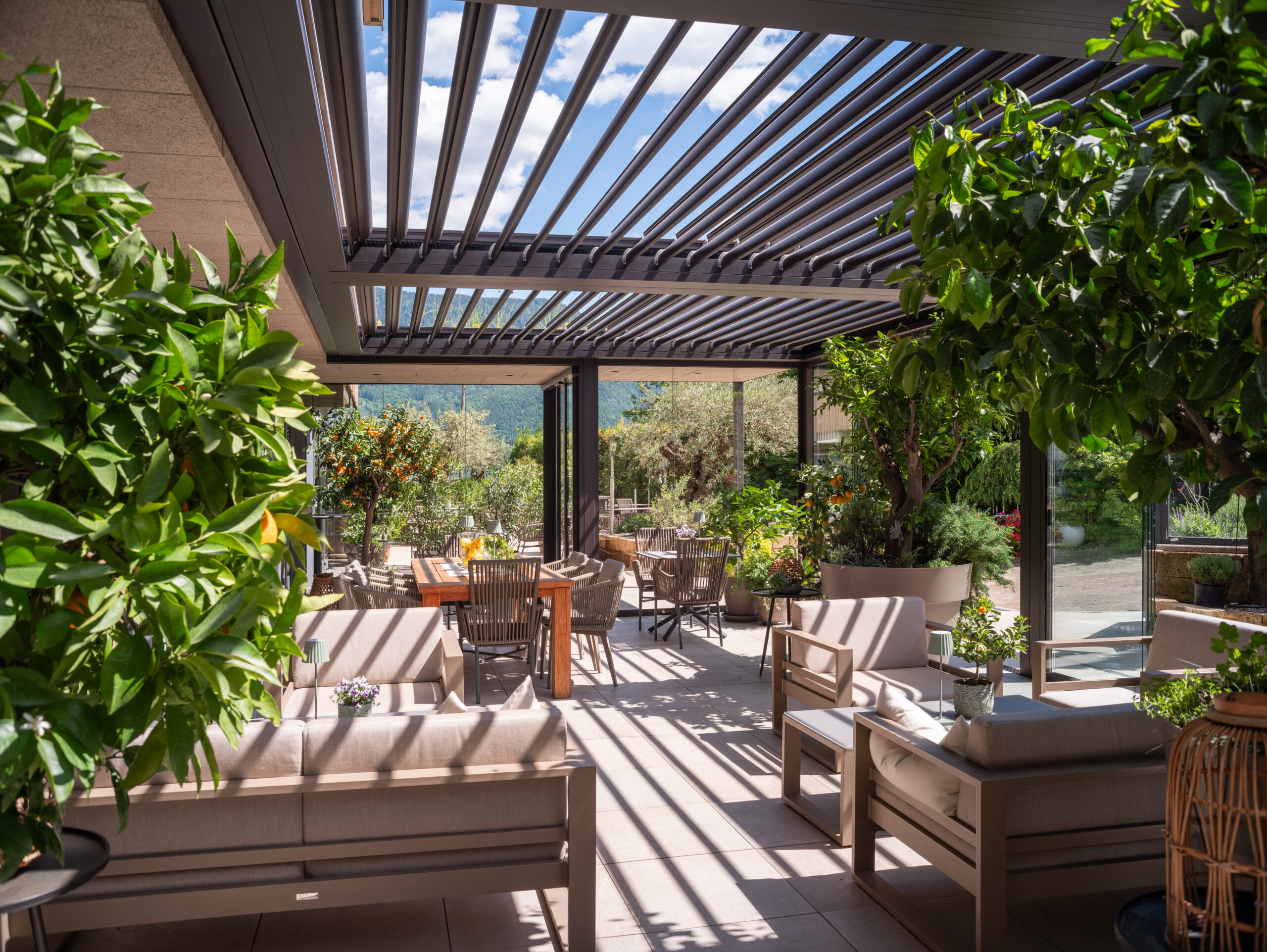 Brustor B600S Lamellendach ueber Gastro-Terrasse mit gedeckten Tischen